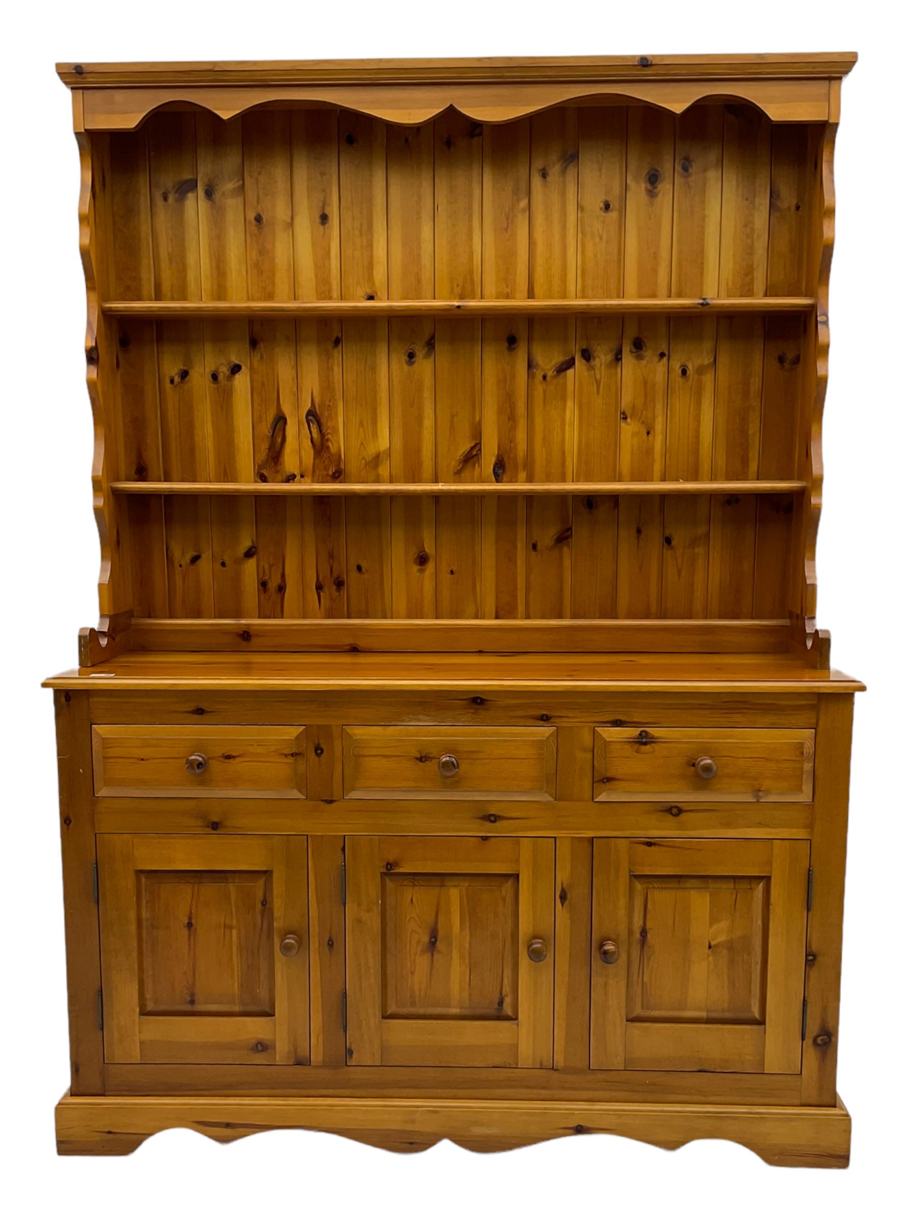Pine farmhouse dresser with three drawers and three cupboards, and two tier plate rack