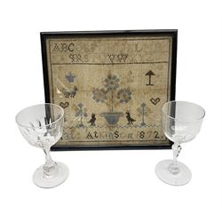 Victorian sampler by Kate Atkinson, dated 1872, depicting flowering urn, birds, trees, and other motifs, beneath an alphabet band, framed and glazed, overall H22.5cm W24.5cm, together with two 19th century drinking glasses, in one box 