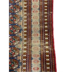 Persian indigo Bokhara rug, decorated with three rows of Gul motifs, within multiple band border 
