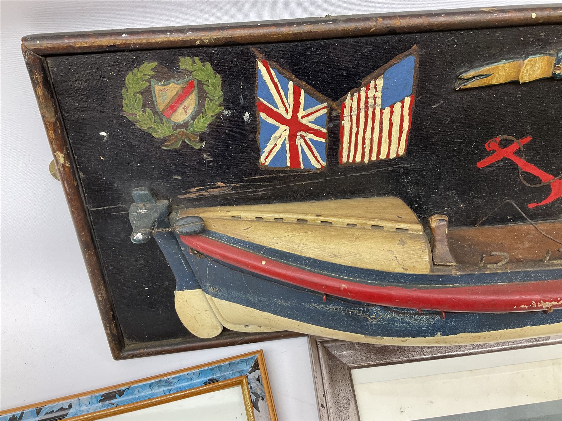 RNLI collection box in the form of a boat makers half block model, painted in the colours of a lifeboat with flag and ship motifs, H25cm, L73cm together with framed photos, postcards and prints of lifeboats and crew, including Scarborough lifeboat station