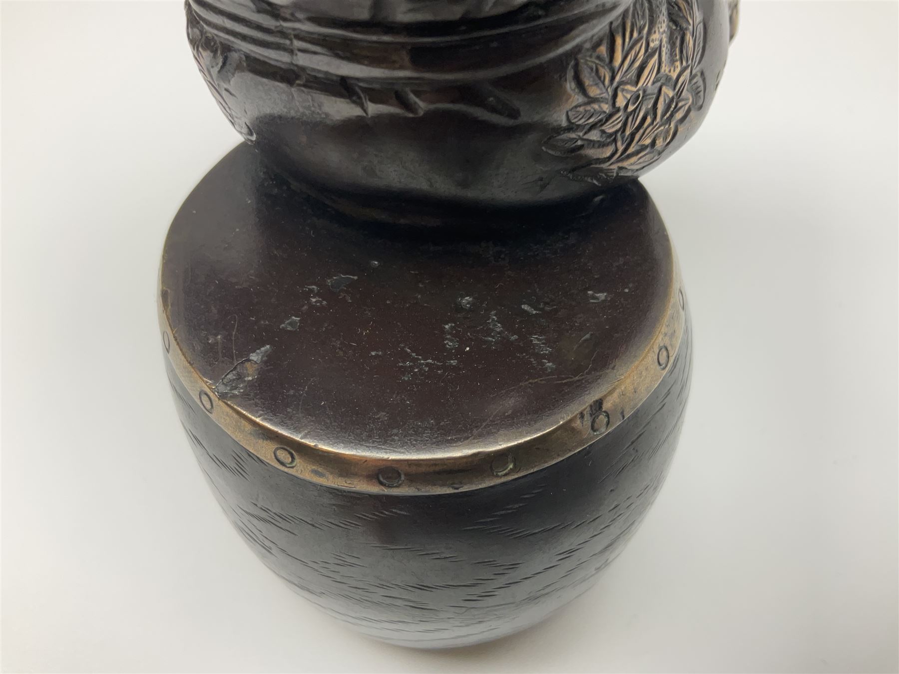 Oriental bronze figure of a gentleman, modelled seated upon barrel with a pipe in one hand and a flask in the other, H21cm