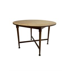 Early 20th century Arts and Crafts period oak table, circular top raised on tapered supports with pad feet, united by X-stretcher