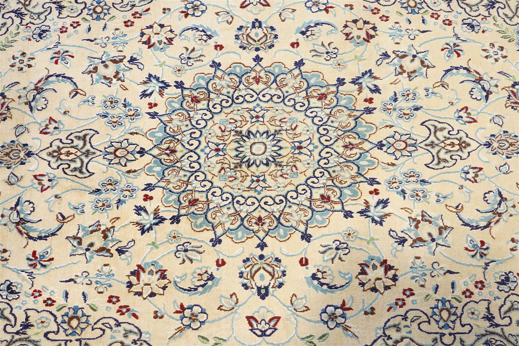 Central Persian Nain hand-knotted silk and wool rug, ivory field with a cusped medallion  issuing radiating pendants, with an all-over design of scrolling arabesques, palmettes and floral sprays, framed main border of meandering vinery and stylized palmettes, flanked by narrow guard stripes, cotton fringe ends  