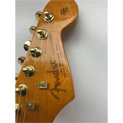 Copy of a Fender Stratocaster electric guitar in black with Wilkinson bridge, lock-in tuners, synchronised tremolo and various patent numbers; L99cm; in hard carrying case with strap and digital tuner