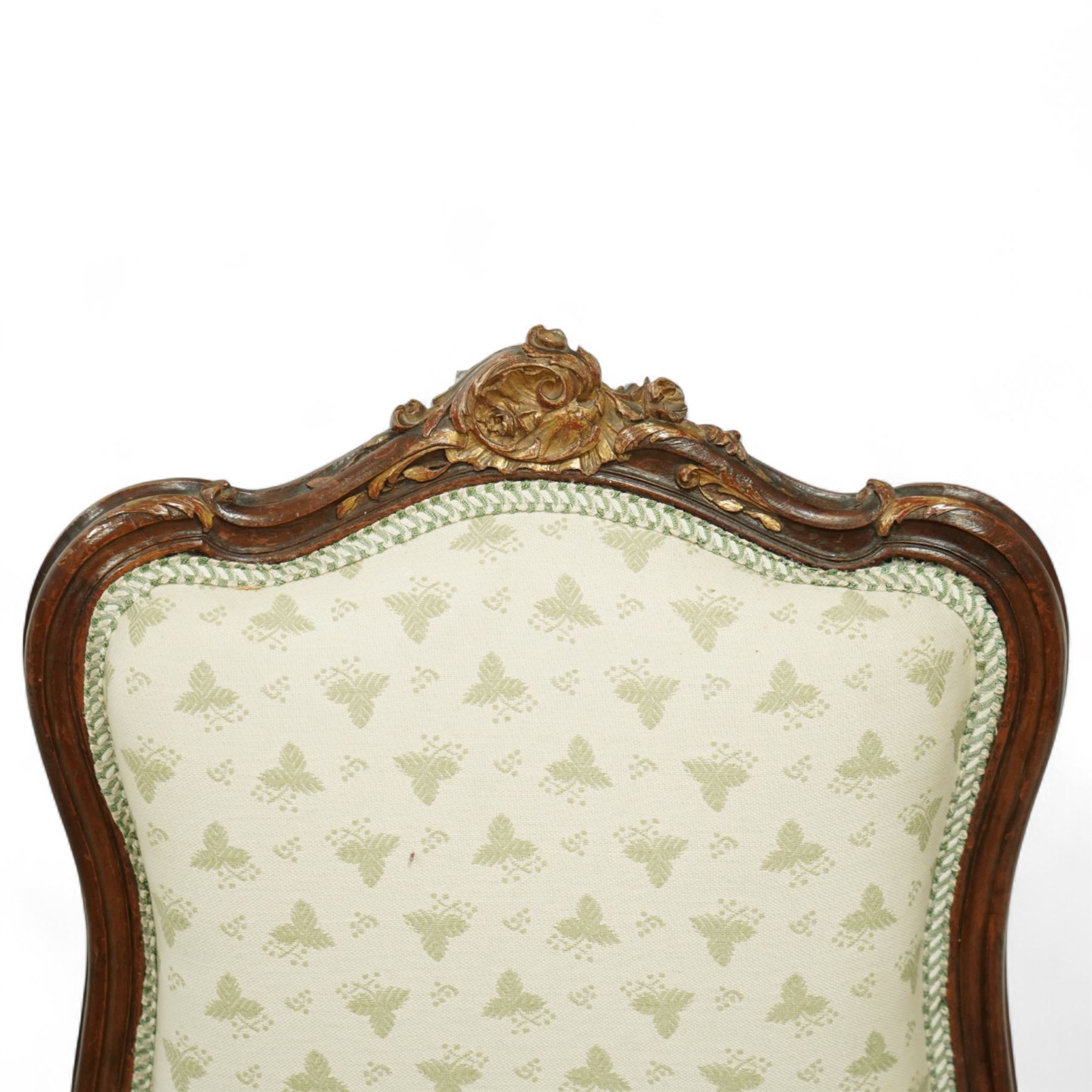 Louis XV design salon suite comprising a pair of walnut and parcel-gilt fauteuil armchairs together with a side chair, the cresting rail surmounted with a carved giltwood floral shell motif with extending foliage, the cartouche shaped backs and sprung seats upholstered in pale blue patterned fabric, over a shaped apron with scallop decoration and foliage carved knees, raised on cabriole supports