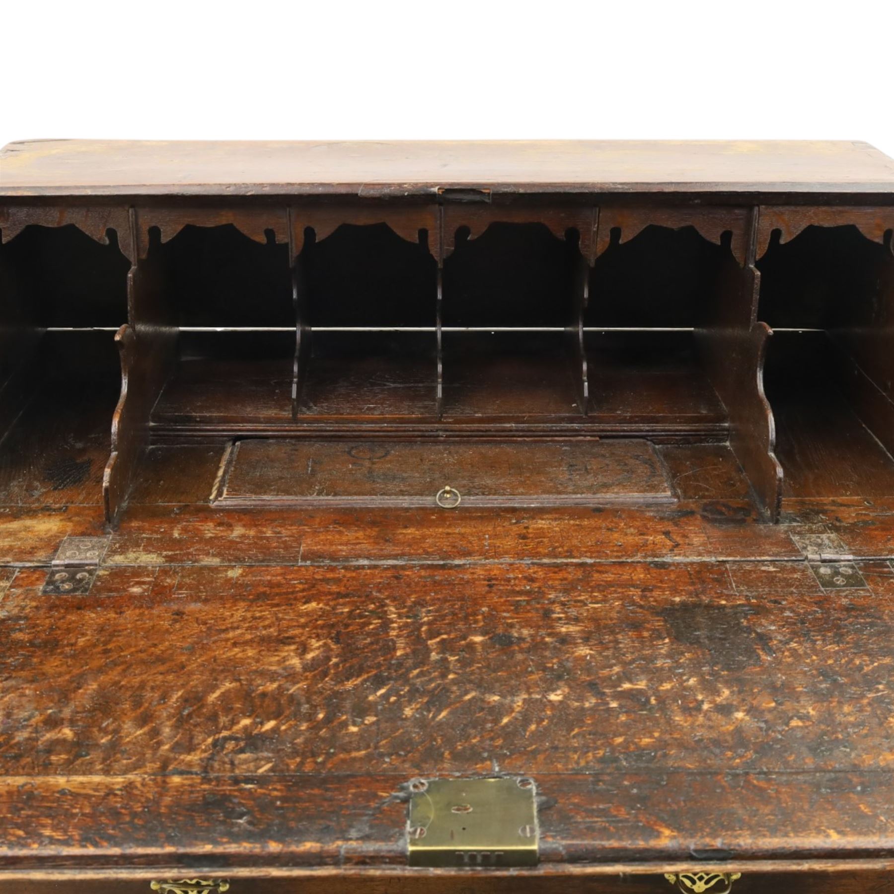 Georgian oak bureau, fall front with pierced brass escutcheon and handles, revealing a fitted interior, above two short over two long drawers, raised on bracket feet