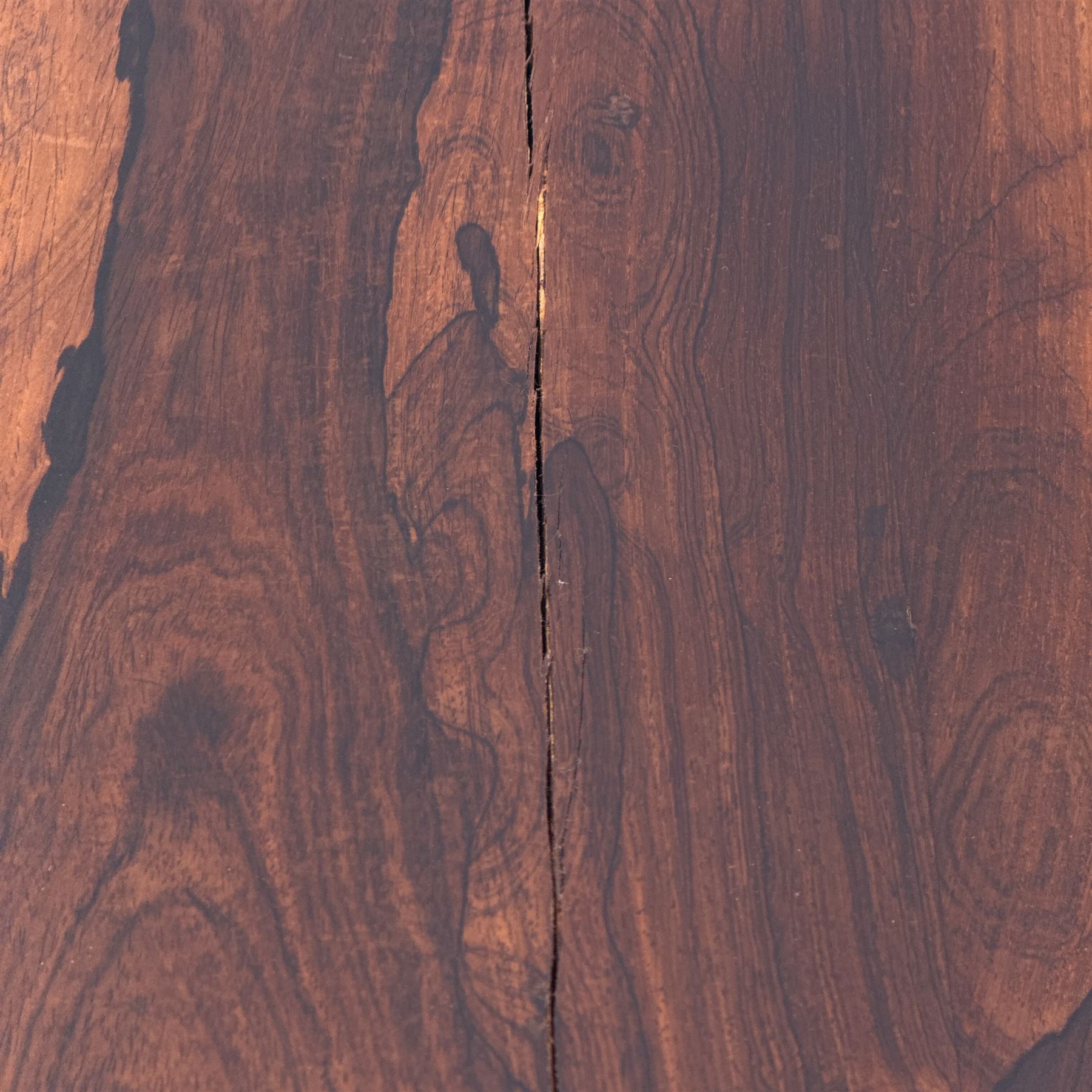 William IV rosewood card table, rounded rectangular swivel and fold-over top with plain frieze, with carved scrolled brackets above stop-fluted column with moulded collar on quadriform base with scrolled feet 