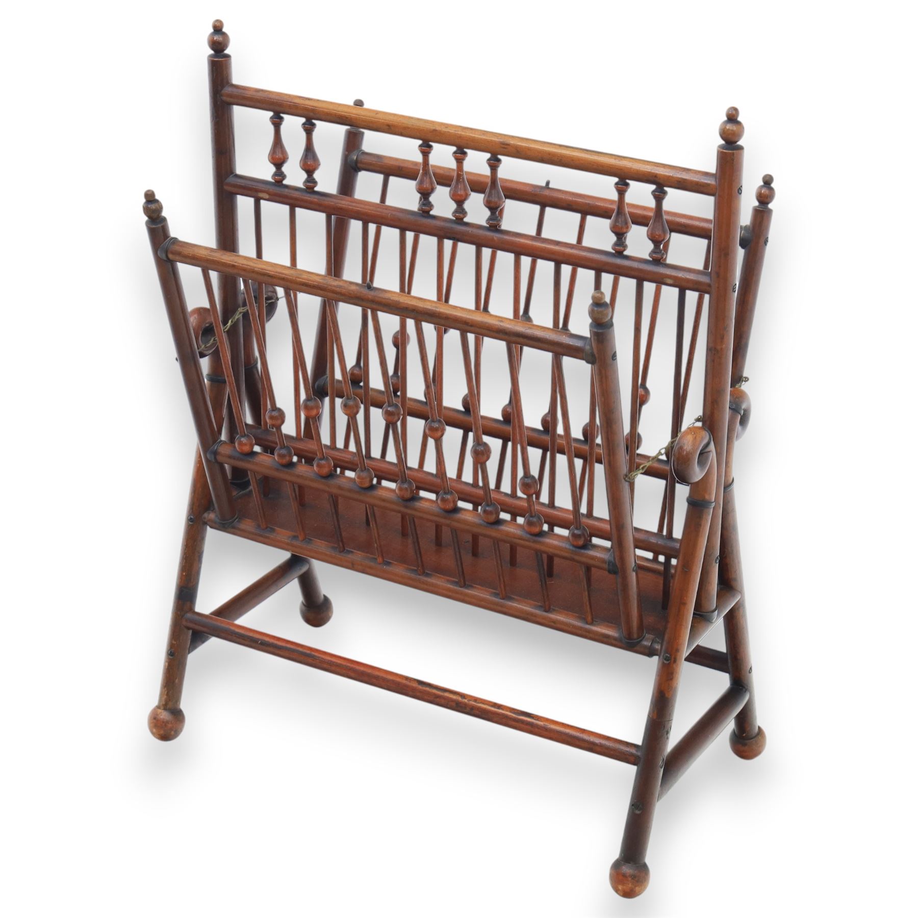 Arts and Crafts mahogany magazine stand, in the manner of Christopher Dresser, folding magazine stand, rectangular divided slatted compartments with turned spindle galleries and ball finials, the sides forming an X-frame action, raised on turned supports united by stretchers