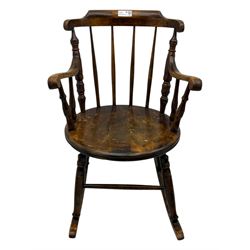 Late 19th century elm and beech Windsor rocking chair, with shaped top rail over turned spindles and curved arms, circular seat raised on turned legs united by stretcher on rockers