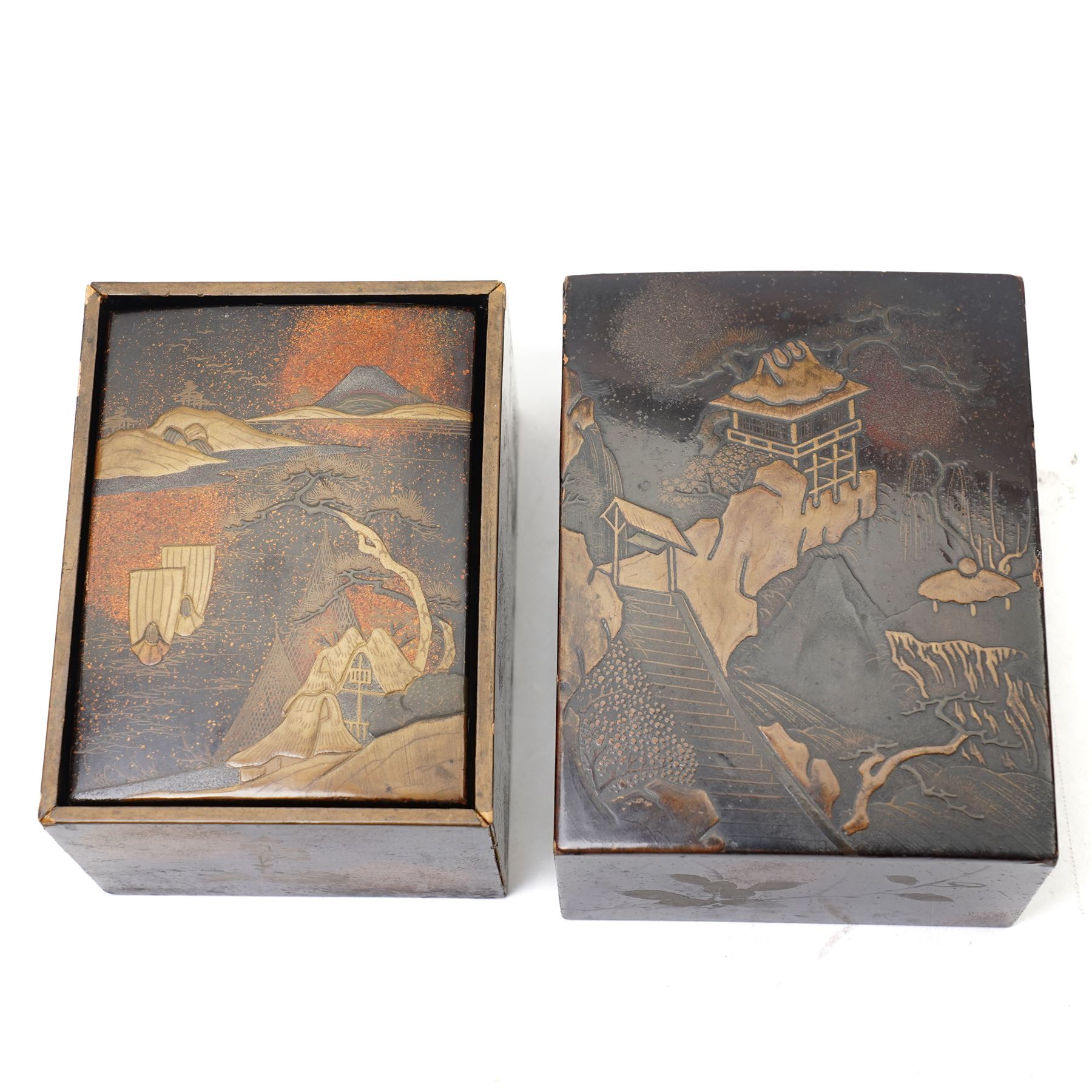 Nest of Japanese Meiji period lacquered boxes, the nashiji ground with maki-e decoration, each cover depicting a traditional landscape, the sides painted with traditional Japanese foliage, larger box H7cm (2)