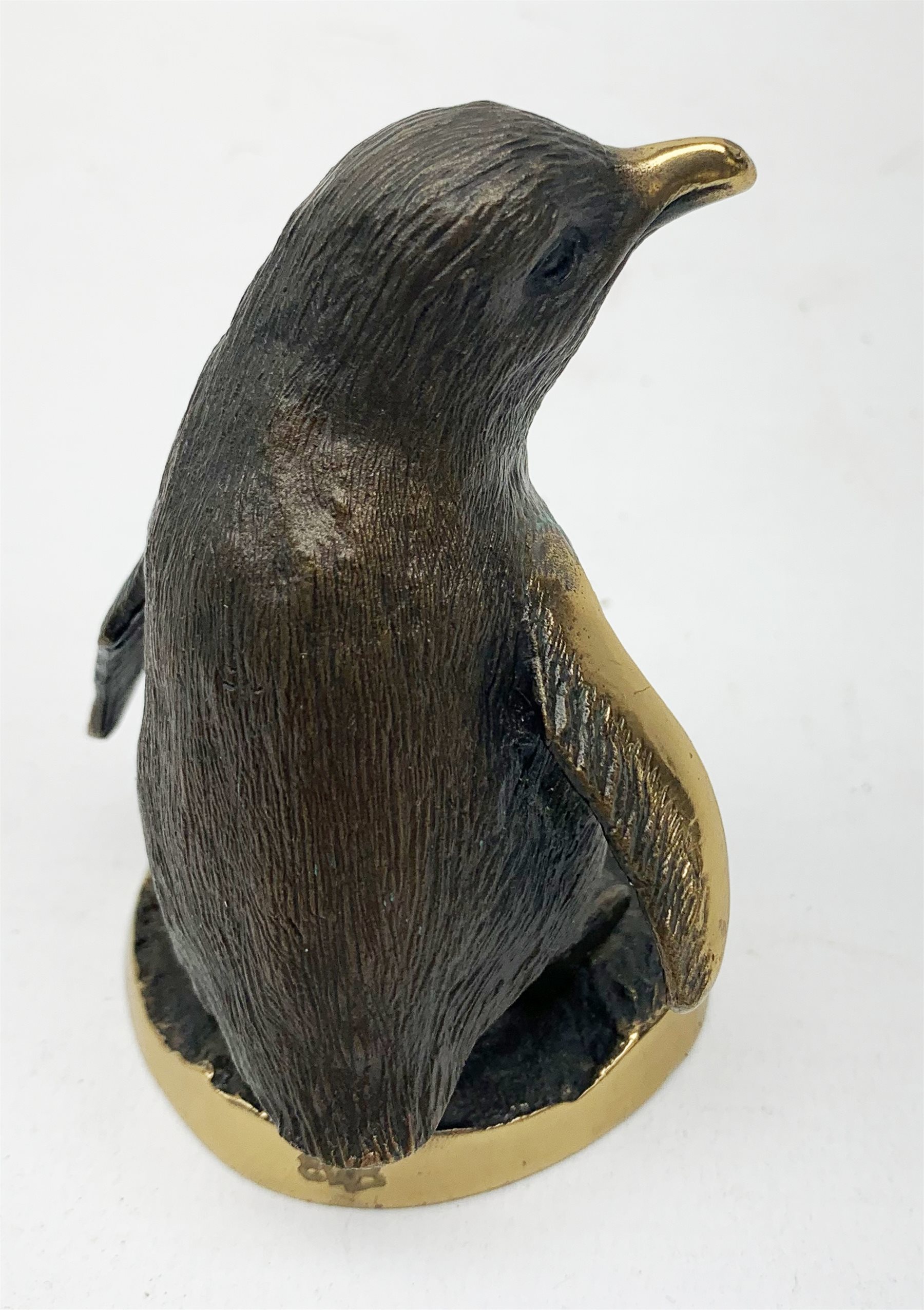 A cold painted model of a Kingfisher surmounted upon a branch surporting a small clear glass bowl, H10.5cm, together with a small bronze model of a penguin, stamped EWB, H7cm. 