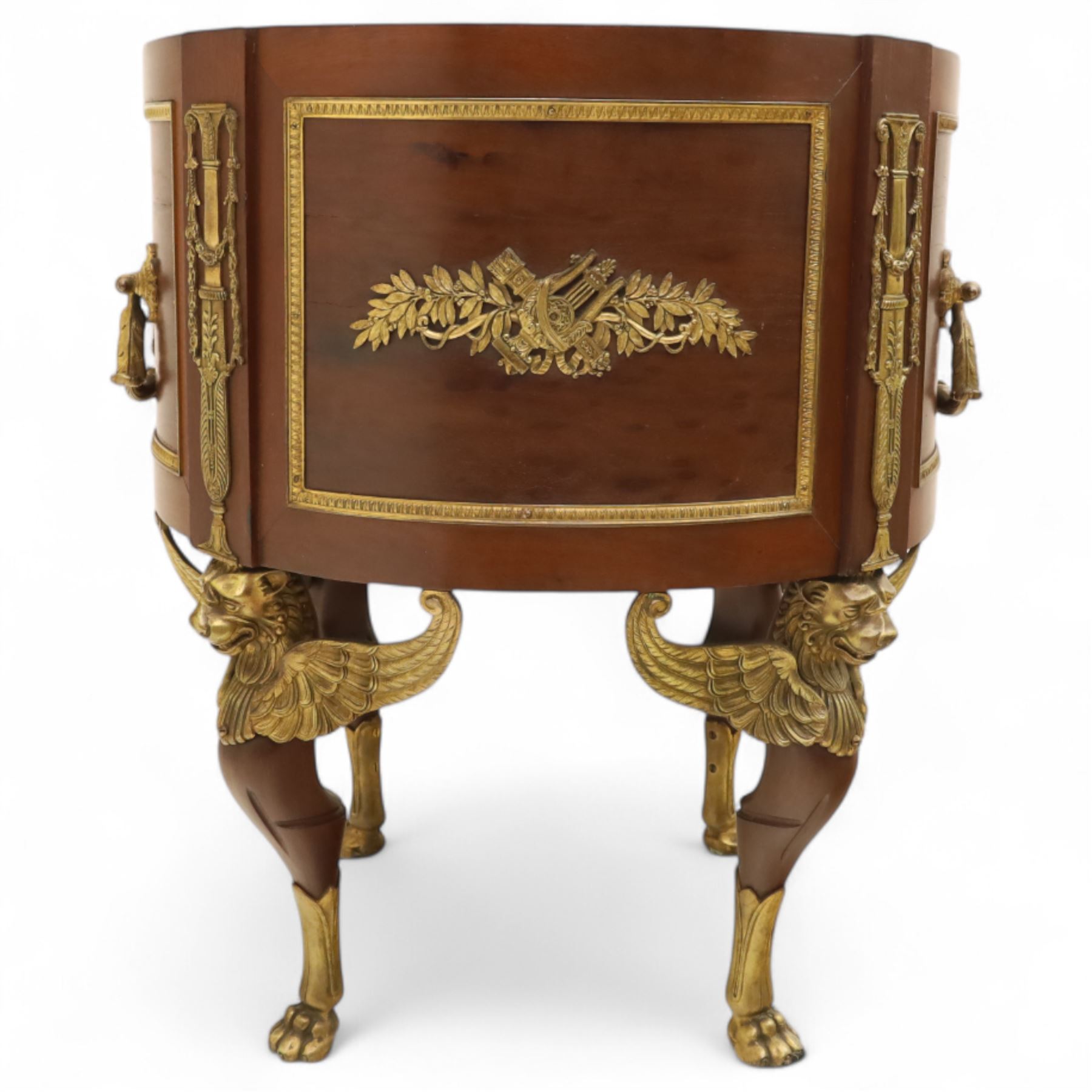 An imposing and richly adorned Empire Revival jardiniere of circular form, decorated with finely cast gilt bronze laurel garlands and floral swags, interior with a modern brass liner, sides with gilt bronze carrying handles, raised on three tripod legs with classical caryatid masks with wings terminating in lion paw feet, circa 1900

Provenance: This jardiniere formed part of the original furnishings of the opulent Empire Room at Kinloch Castle, built by industrialist George Bullough in 1900.

An original inventory number, ‘X954’, is inscribed on one facing, verifying its presence in the Kinloch Castle collection. This jardiniere epitomises the lavish taste of the Edwardian elite and the high standards of craftsmanship employed in the furnishing of Kinloch Castle, the first private home in Scotland to be lit by electricity and famed for its extravagant interiors.


