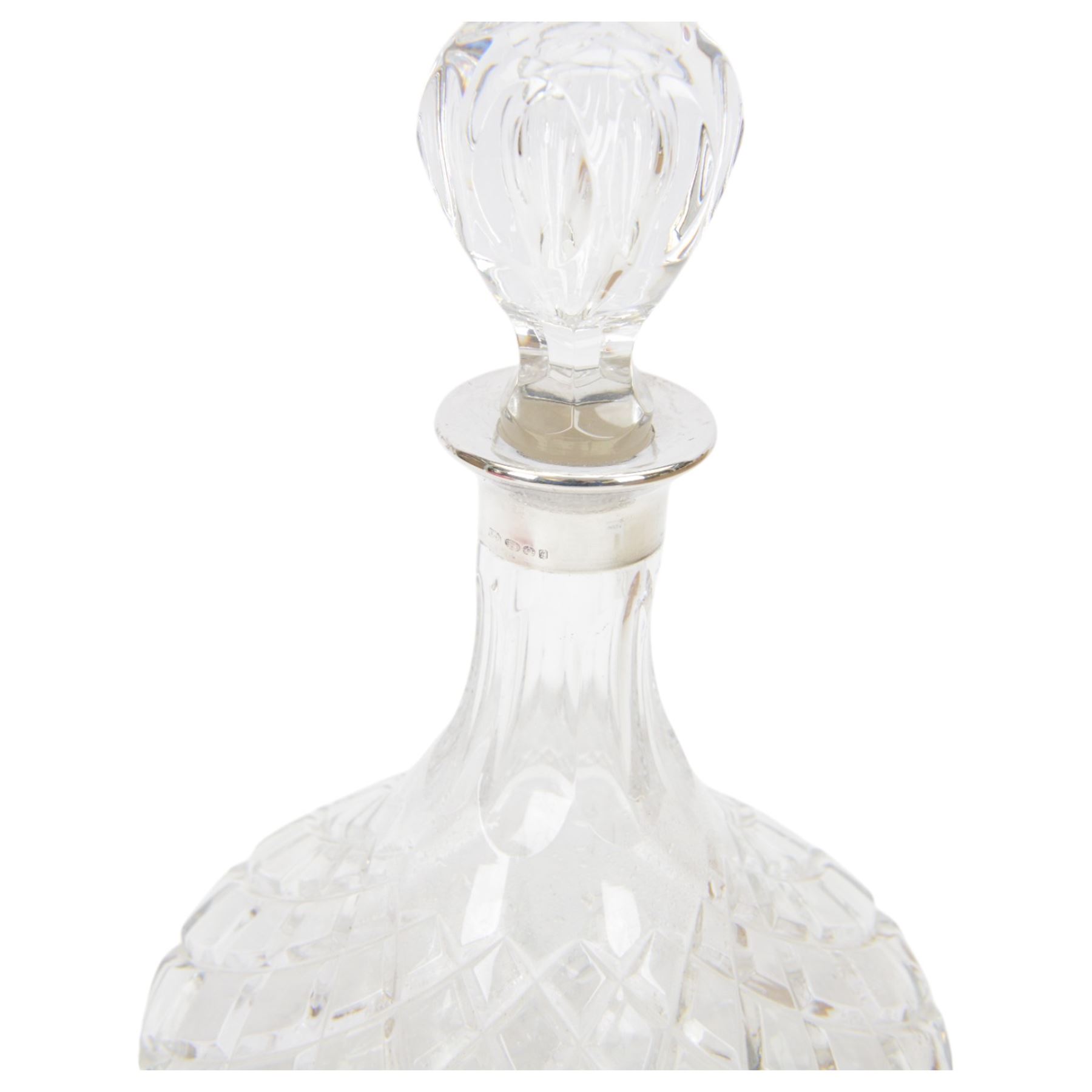 Two modern silver mounted glass decanters, the first a cranberry glass example, with fluted body, clear stopper and silver collar, hallmarked Barker Brothers Silver Ltd, Birmingham 2001, together with a clear cut glass example with silver collar, with import marks for London 1985, tallest H25.5cm