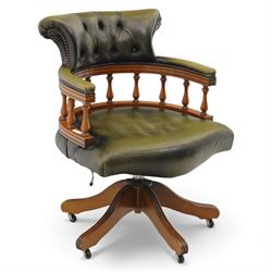 Late 20th century swivel captain’s desk chair, green buttoned vinyl upholstered back and seat with brass stud edging, the spindle gallery over a rotating base with five splayed supports on castors