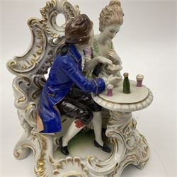 Figure group, probably Volkstedt, modelled as a courting couple seated before a table, the ornate bench and table conforming with and leading from the gilt heightened scrolling base, with blue painted mark beneath, H14.5cm
