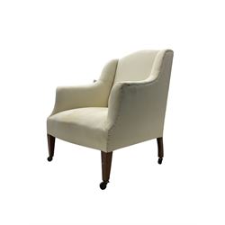 Edwardian wingback armchair, upholstered in white frame cover with sprung back and seat, raised on square tapering supports with castors
