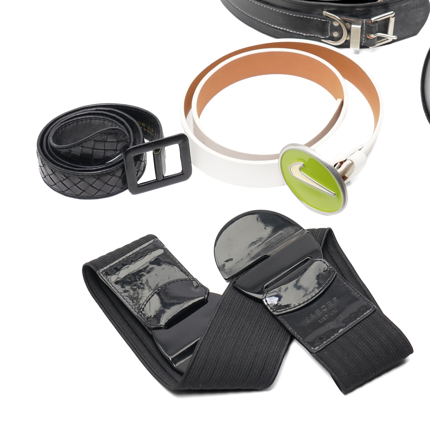 Collection of belts, including white Nike Golf leather belt with oval green and silver Nike swoosh buckle, white Nike leather belt in perforated pattern, black Aigner crocodile-embossed leather belt with large gold buckle, black Jaeger quilted leather belt with rectangular gold buckle, etc (10)