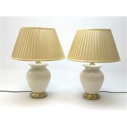 A pair of white crackle glaze table lamps, of ovoid form, with brushed brass effect base and pleated shades, overall H46.5cm. 
