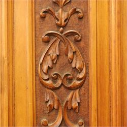 Edwardian walnut triple combination wardrobe, projecting pediment with pierced foliate scroll cresting above a central cupboard flanked by bevelled mirrored doors, over open recess with mirrored back, above two short and three long drawers with brass handles, interior fitted with hanging rails and shelf, raised on plinth base