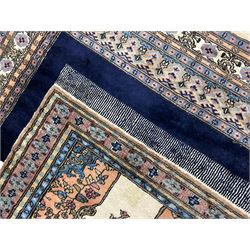 Indo-Persian indigo ground rug, the field depicting a rug with floral medallion and spandrels, enclosed within multiple floral pattern border bands