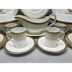 Royal Doulton Royal Gold pattern tea and dinner service for eight, comprising dinner plates, side plates, tea plates, soup bowls, sauce boat and saucer, dessert bowls, coffee cans and saucers, teacups and saucers and two lidded tureens