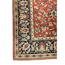 Large Persian design red ground rug, the field decorated with interlacing branches and stylised plant motifs, repeating border with further plant and floral motifs