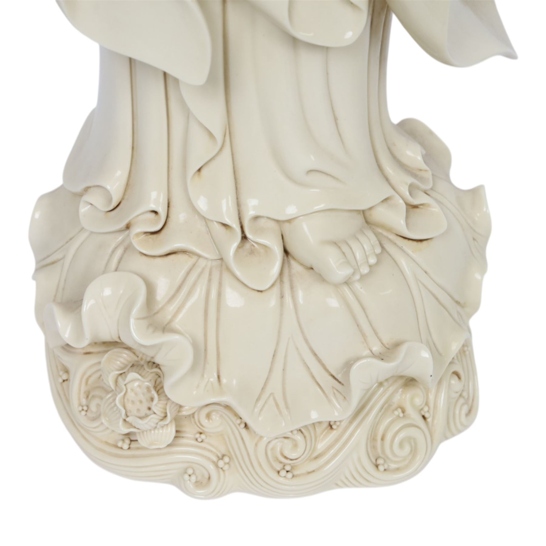 Large Chinese blanc de chine figure of Guanyin, depicting the goddess stood upon a lotus leaf with one hand raised, with potters seal mark to the reverse, H75cm