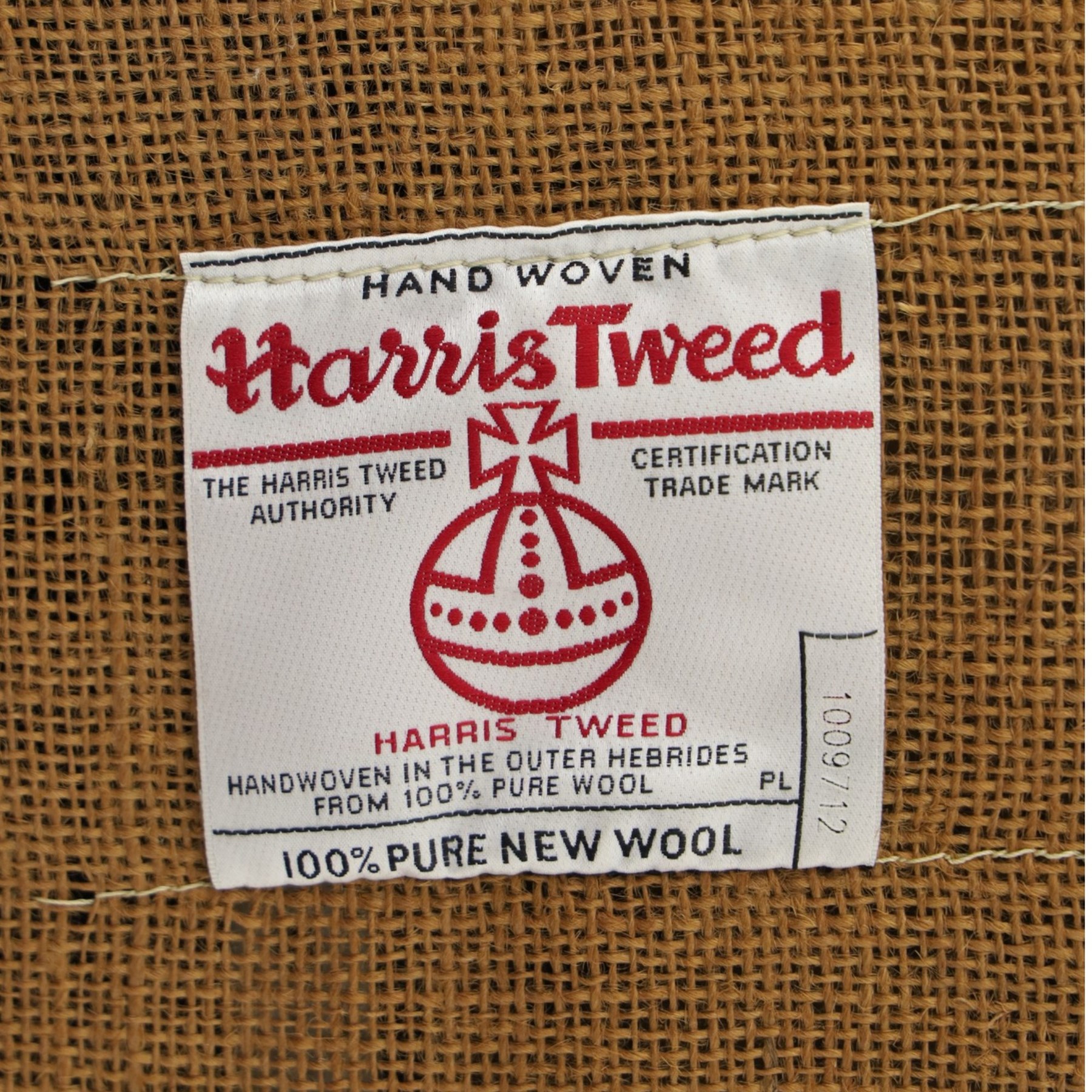 Tetrad - 'Taransay' Harris Tweed and tan leather club armchair, Howard shape with reclined back over deep seat and rolled arms with studwork, raised on turned front supports with castors, the sides and arms upholstered in tan leather with seat and back in herringbone-stitched Harris Tweed