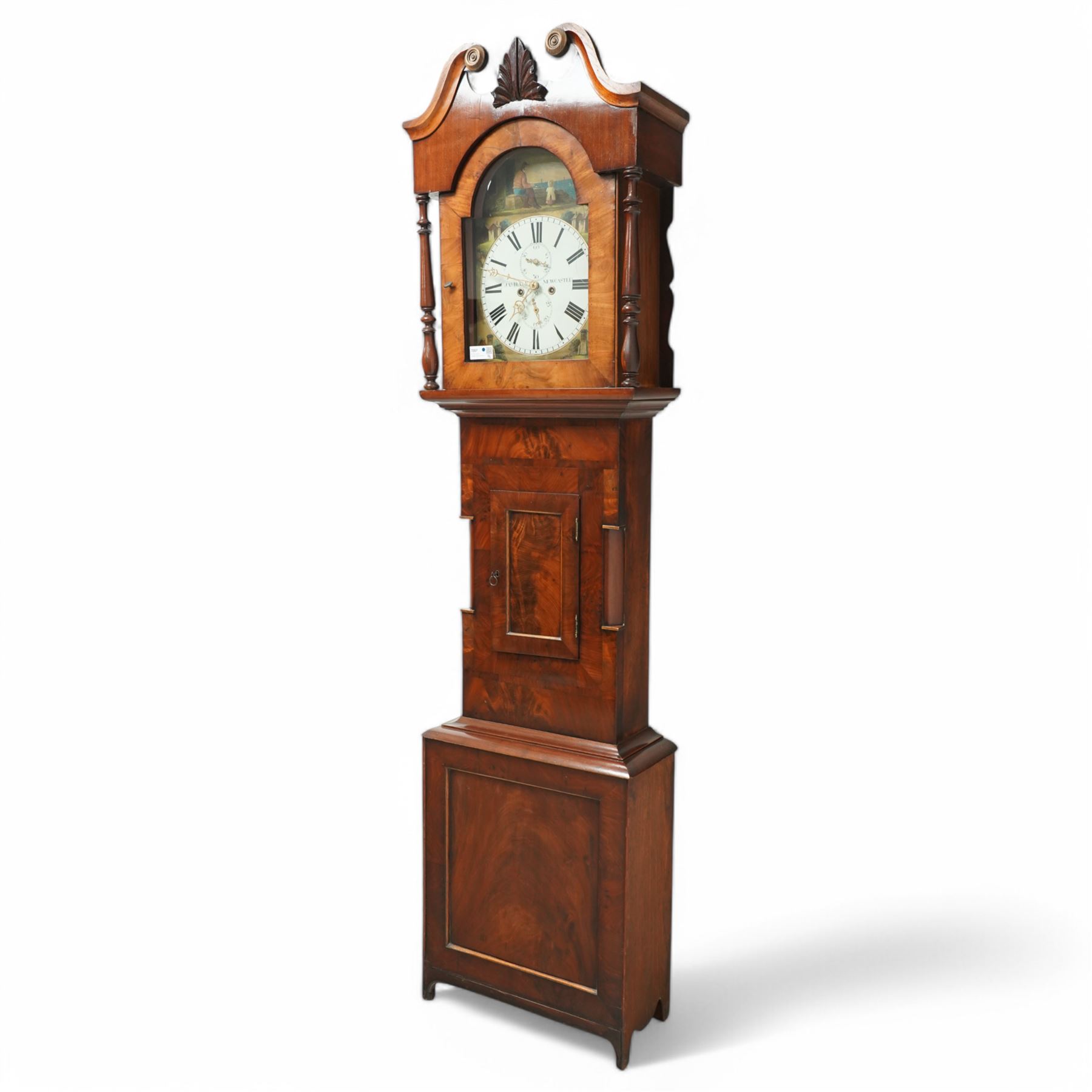 James Hall of Newcastle-Late19th century mahogany longcase clock c1870, with a swan necked pediment and break arch hood door beneath flanked by ring turned pilasters, trunk with half-round inset pilasters and a short panelled trunk door, on a square plinth with a recessed panel, painted dial with spandrels depicting country cottages and a coastal scene of a child and fisherman to the arch, with Roman numerals, minute track, date and seconds dial and stamped brass hands, dial attached via a false plate to a rack striking movement striking the hours on a bell. With weights and pendulum. 
James Hall is recorded as working  from King Street Newcastle-upon-Tyne from 1850 onwards. 
This clock was the subject of a detailed article on both the clock and maker, published in CLOCKS magazine in 2009. 
