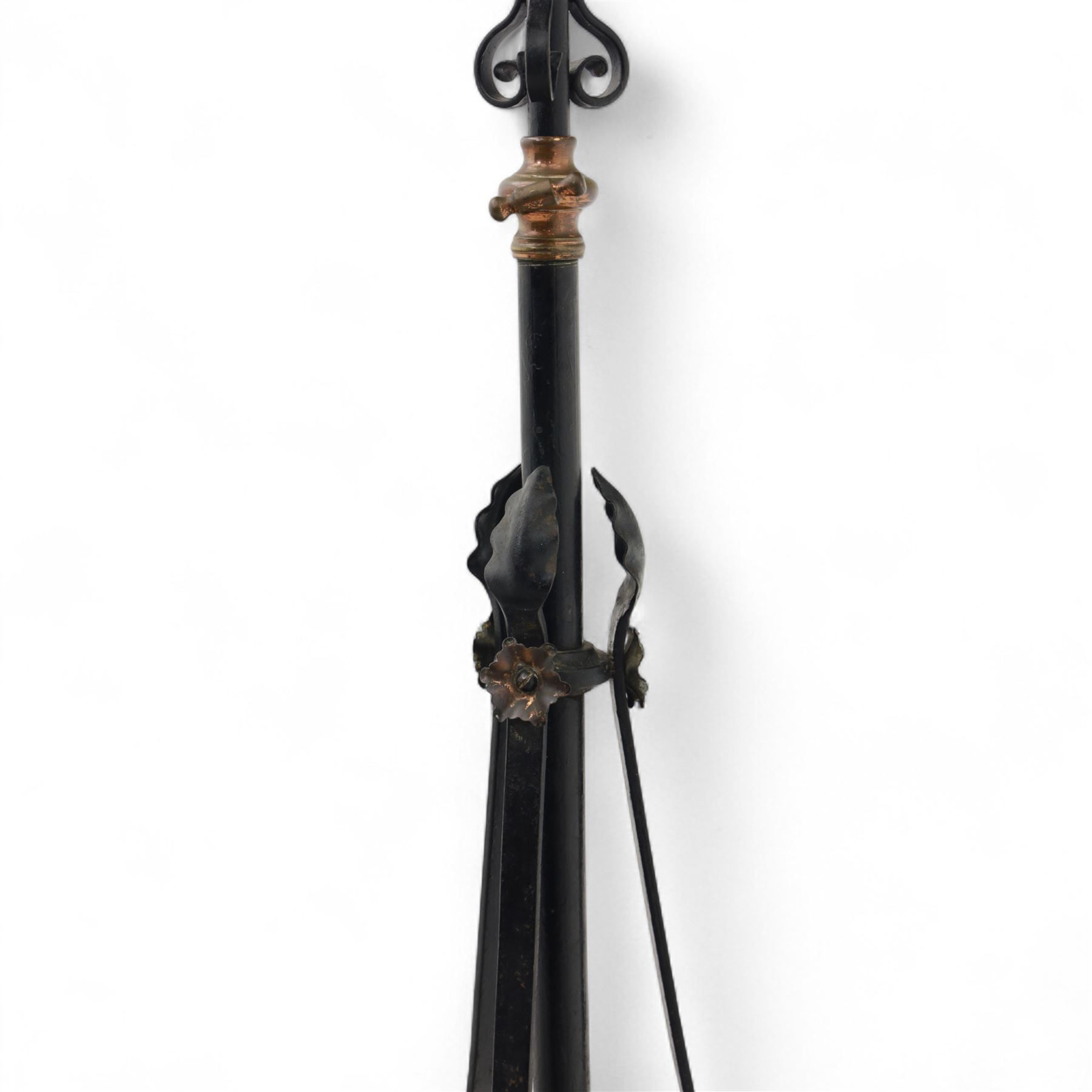 Early 20th century converted oil lamp standard, with copper reservoir and brass burner mount, later wired for electricity, on wrought iron tripod stand with scroll and twist ornamentation