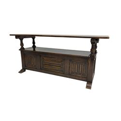 Jacobean design oak Monks bench, the front with carved linenfold panels, hinged metaphoric table back, hinged box seat compartment, on sledge feet