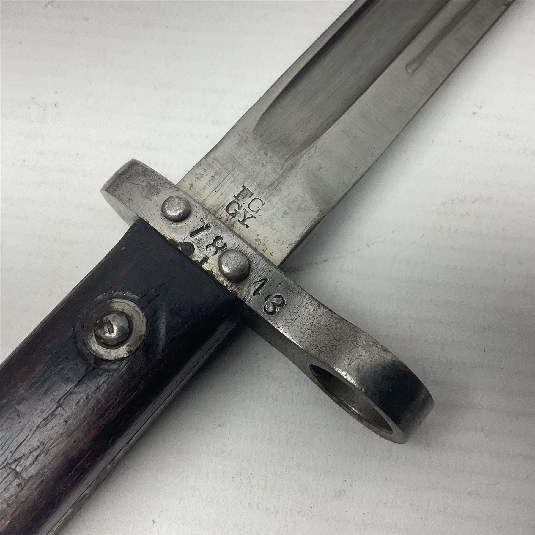 Austrian Model 1895 Carbine knife bayonet with 24.5cm fullered steel blade; various marks to the ricasso including F.G. GY.; cross-piece marked No.7843; in steel scabbard L37cm overall