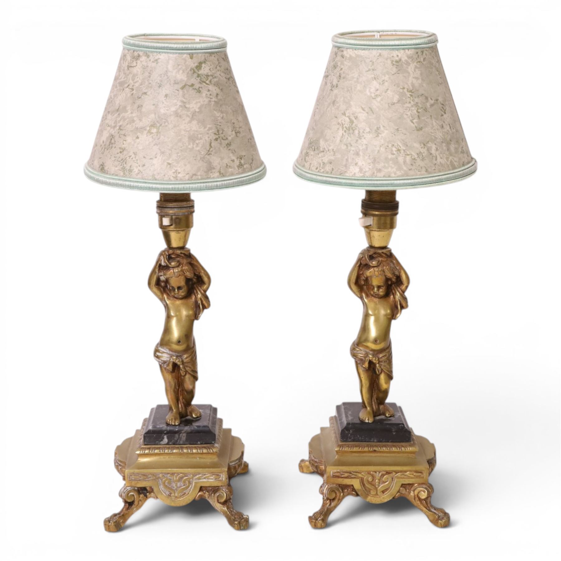 Pair of brass table lamps, the central column modeled as a putti upon a square marble base raised upon four claw feet, H29cm