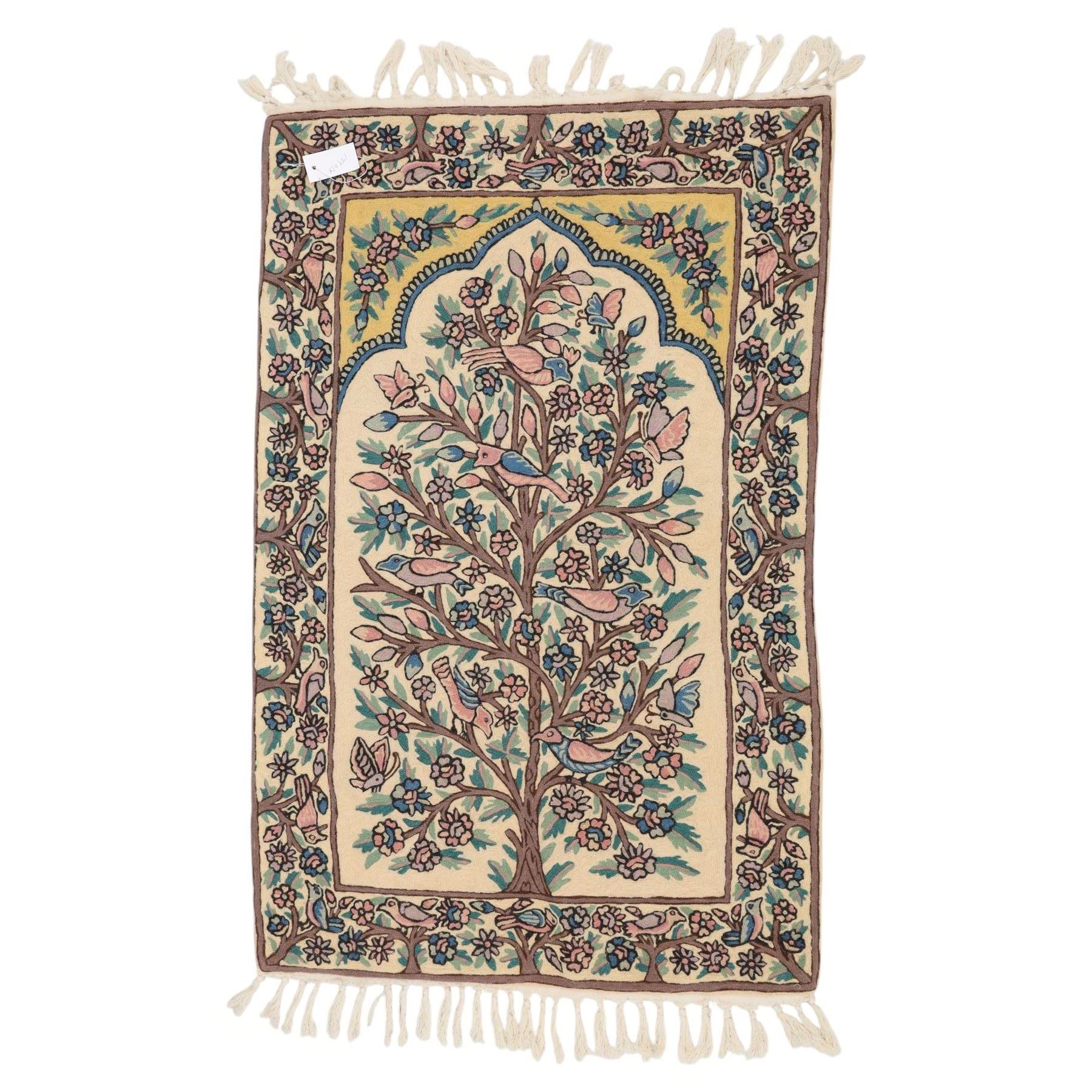 Kashmiri chain stitch crewel embroidered wall hanging, the tree of life design embroidered on a cream ground with coloured pastel tones of rose, teal blue, and light brown in an arched mihrab style framing 