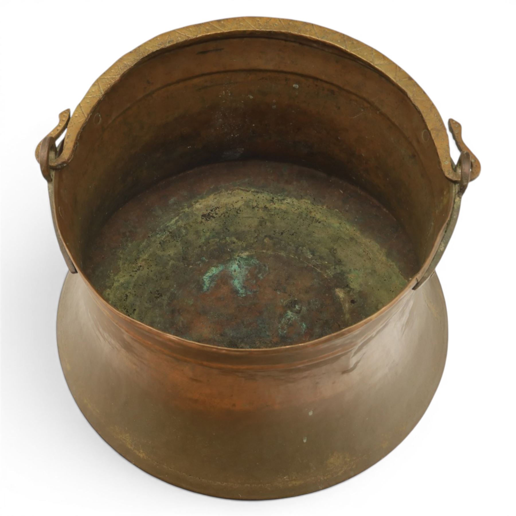 19th century brass and copper cauldron, circular open body with rolled rim, riveted side mounts and swing carrying handle, on broad flared circular foot