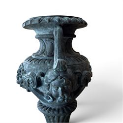 Large impressive Classical cast bronze center-piece urn, twin scroll handles with grape garlands, cherub masks and relief detail, raised on a circular cast stone pedestal with moulded detail