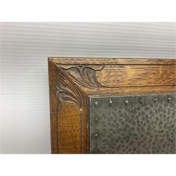 Arts and Crafts oak stand by Arthur Simpson of Kendal, of rectangular form with central hammered pewter panel, surrounded by a border with carved foliate corners, upon two bar supports, bearing label detailed 