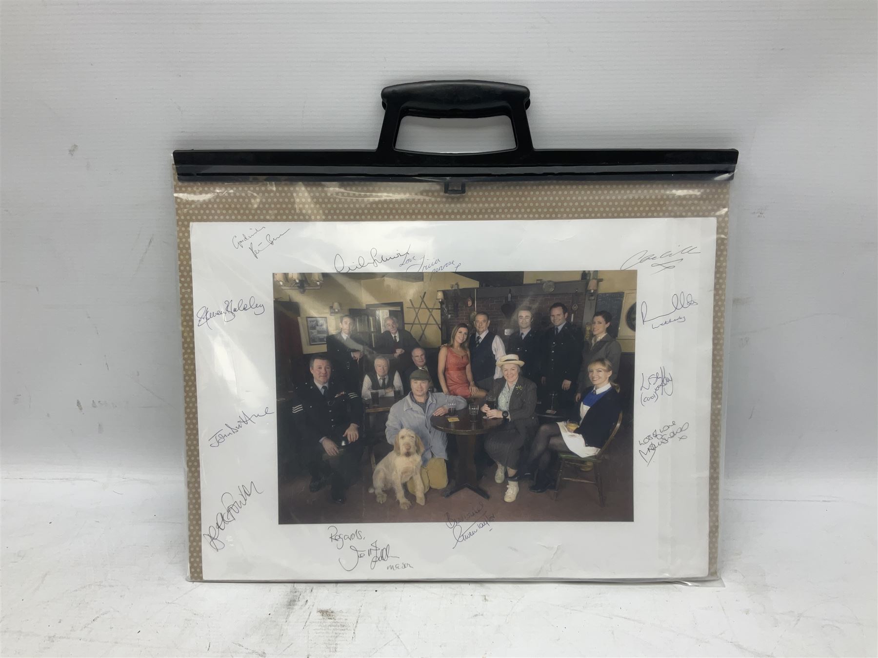 Photograph of the cast of Heartbeat posing in costume in the Aidensfield Arms and signed by twelve cast members including John Duttine, Tricia Penrose, Clare Wille, Derek Fowlds, Gwen Taylor, Lisa Kay, Peter Benson etc; unframed