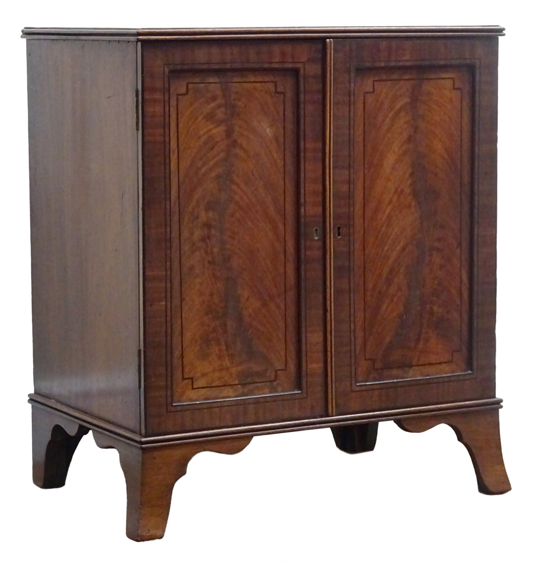 Regency ebony strung mahogany medal or coin collectors cabinet, with reeded top, two panel doors enclosing eleven drawers, shaped out splayed bracket feet