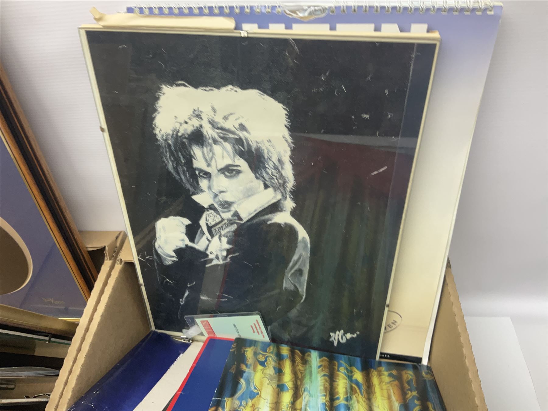 Mostly Queen and Freddie Mercury interest items, including pin badges, newspaper cuttings, diecast 'promotional' vehicles, special edition Pop Rocks figure of Freddie Mercury, VHS tapes, two charity certificates signed by Brian May and Roger Taylor, poster etc, in two boxes 