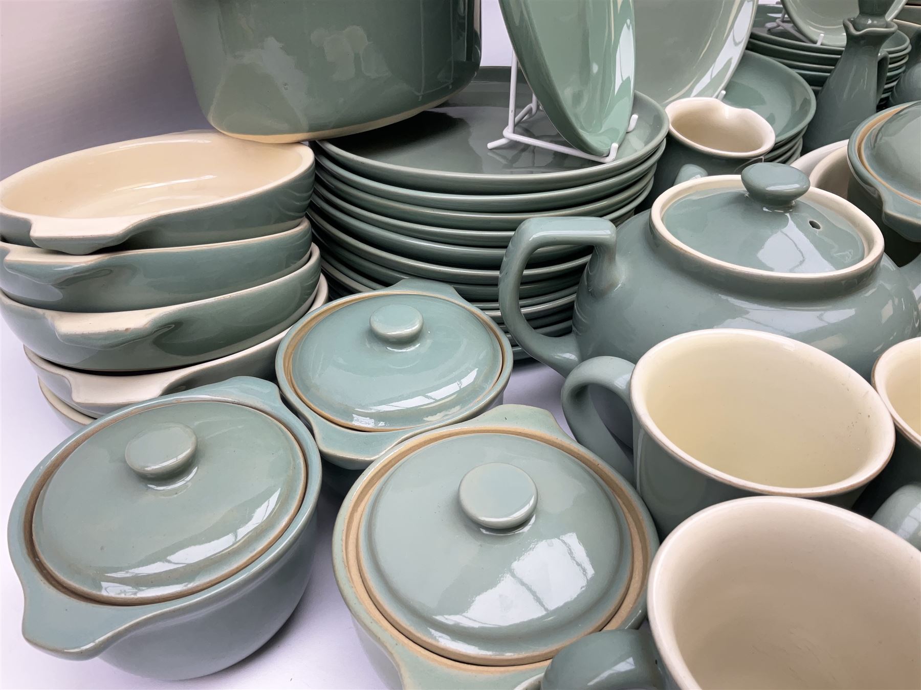 Denby Manor Green pattern part tea and dinner service, to include seven dinner plates, thirteen side plates, ten dessert plates, two oval dishes of various sizes, four cups and saucers, seven bowls with covers, two teapots etc (74)  