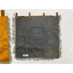 Two replica German Luftwaffe trumpet banners, one heavily silver wire embroidered with Luftwaffe eagle in a wreath, on an amber, white and black rayed background, , with silver wire tasselled border and four leather hanging loops, approx. 50 x 49cm; the other slightly larger heavily gold wire embroidered with the Luftwaffe eagle on a plain amber ground with gold wire tasselled border and two hanging loops (2)