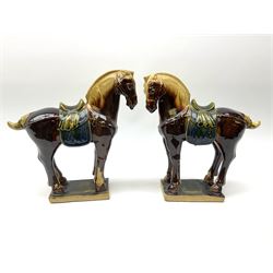 A pair of glazed pottery Tang style horses, each with impressed marks beneath, each approximately H25.5cm. 