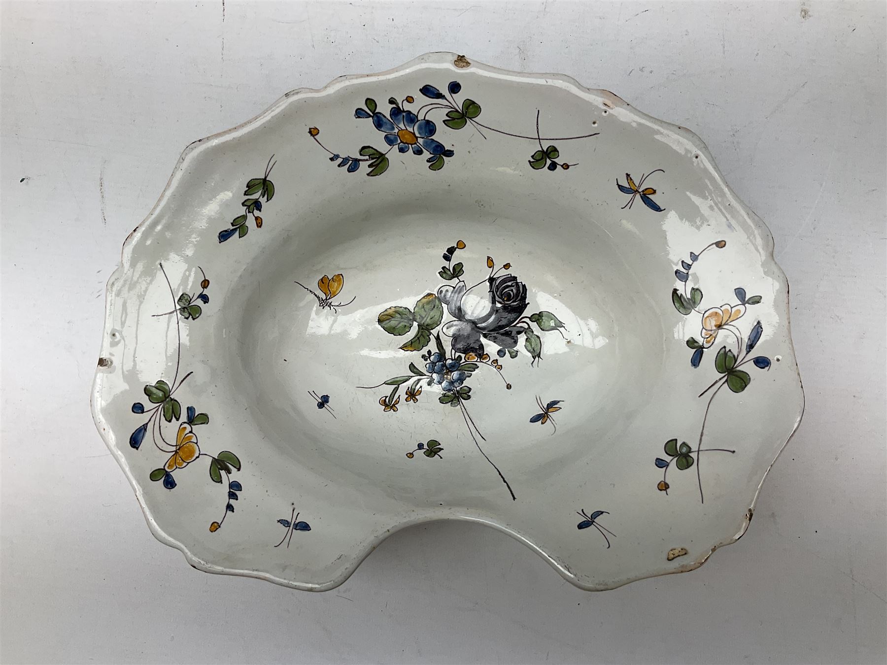 19th century French faience barber's blood-letting bowl, with painted floral decoration in polychrome upon plain ground, with painted initials CT mark beneath, L31cm