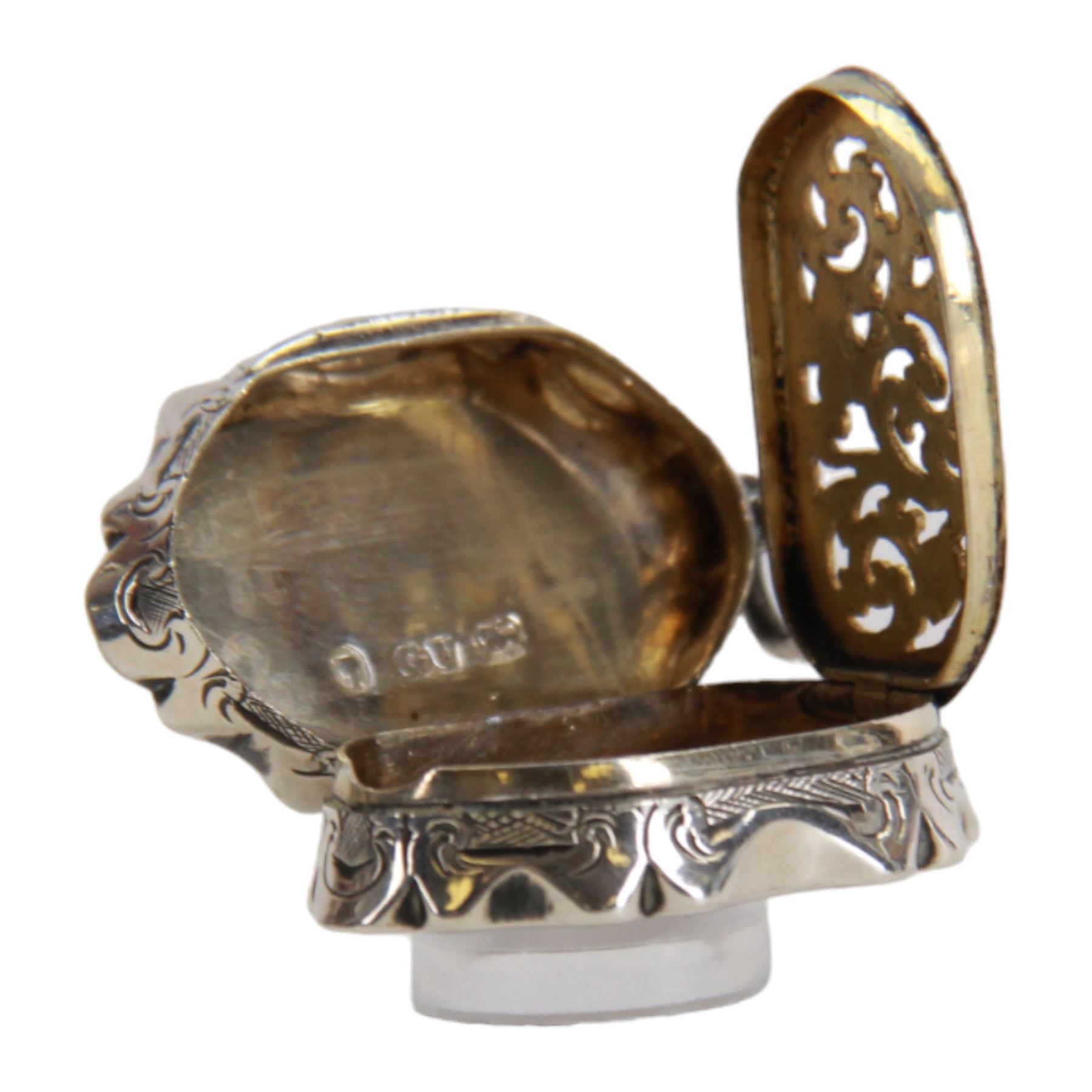Victorian silver vinaigrette, of oval form with shaped edge, decorated throughout with engine turned bands, the hinged cover with vacant C scroll panel opening to reveal a foliate pierced grille and gilt interior, hallmarked George Unite, Birmingham 1857, L3.5cm