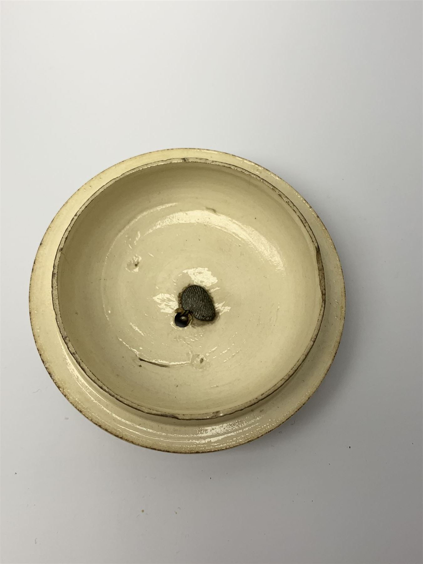 18th century creamware teapot, probably Leeds, with reeded entwined handle and floral finial to the cover, the body with hand painted polychrome decoration of figure to one side, and floral spray to the other, collectors paper label beneath inscribed Leeds Pottery, H11.5cm