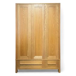 Contemporary light oak triple wardrobe, panelled doors with vertical linear design, left section enclosing hanging rail and single shelf, right section with adjustable shelves, over two drawers, on square stile supports