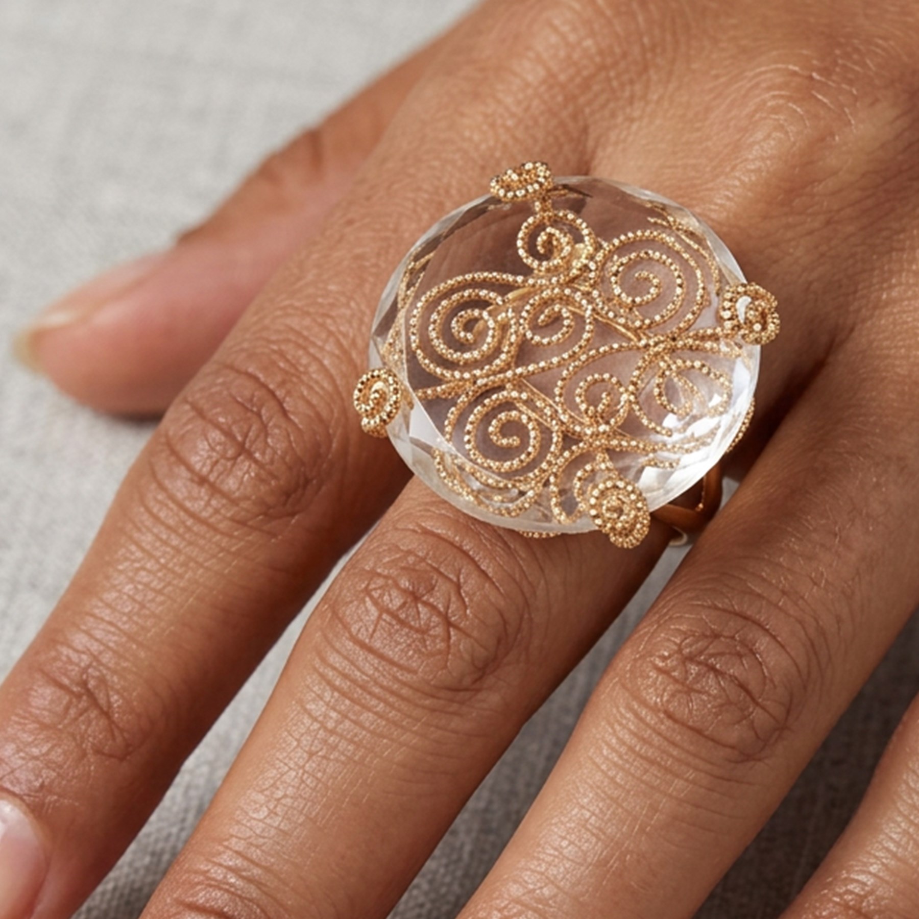 18ct gold rock crystal ring, single round cut crystal, mounted in a fancy textured swirl under setting, stamped 750