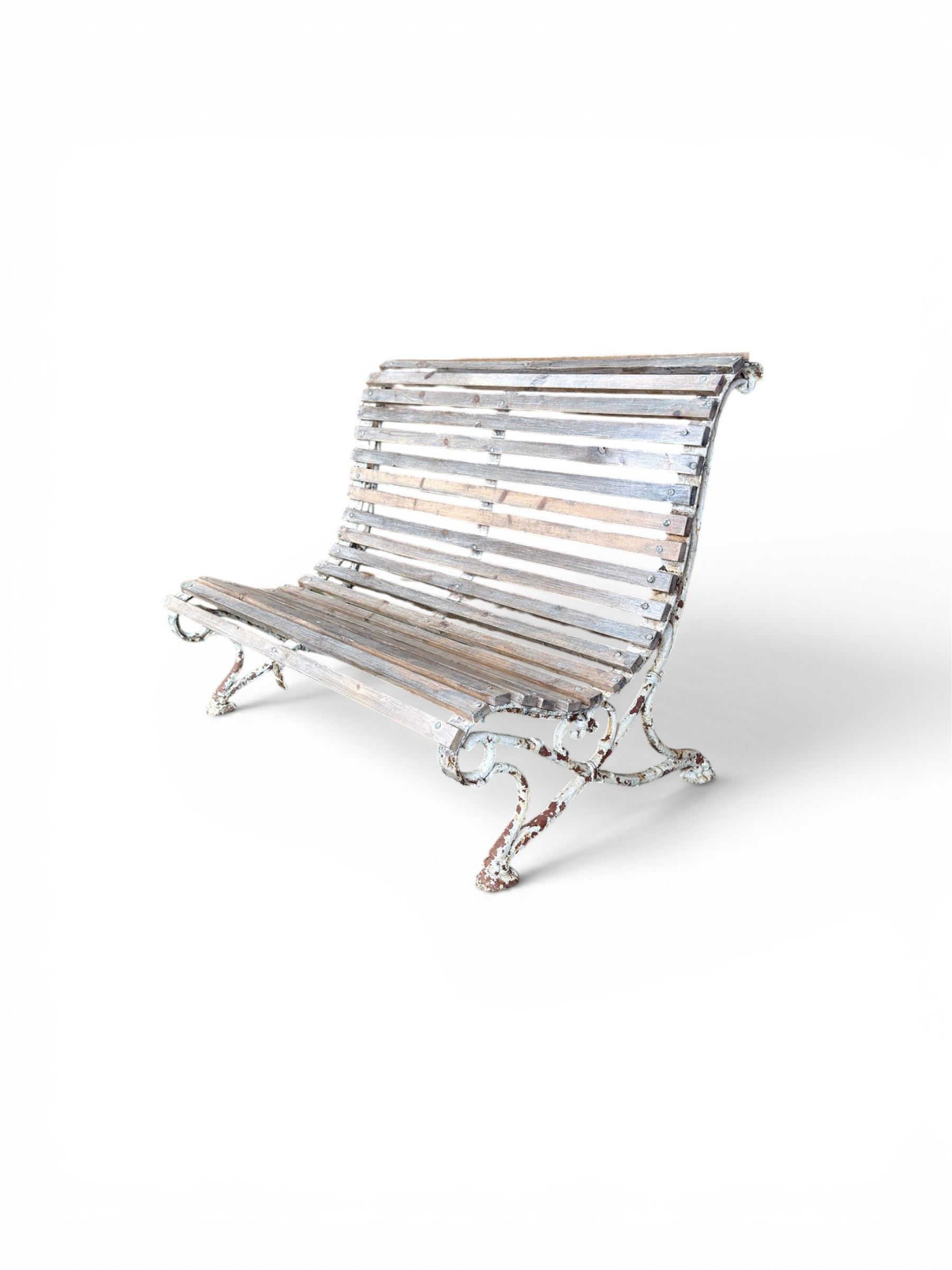 19th century cast iron and wood slatted garden bench, high scroll back form, low X shaped base, finished in distressed white paint