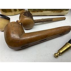 Swiss mountain hunters tobacco pipe with a horn mouthpiece, metal hinged pierced lid and brass chain, the black coated body adorned with small metal cow flowers, together with two other pipes and case, brass mounted horn, brass mounted bone box, carved mother of pearl handled knife and fork and brass jug